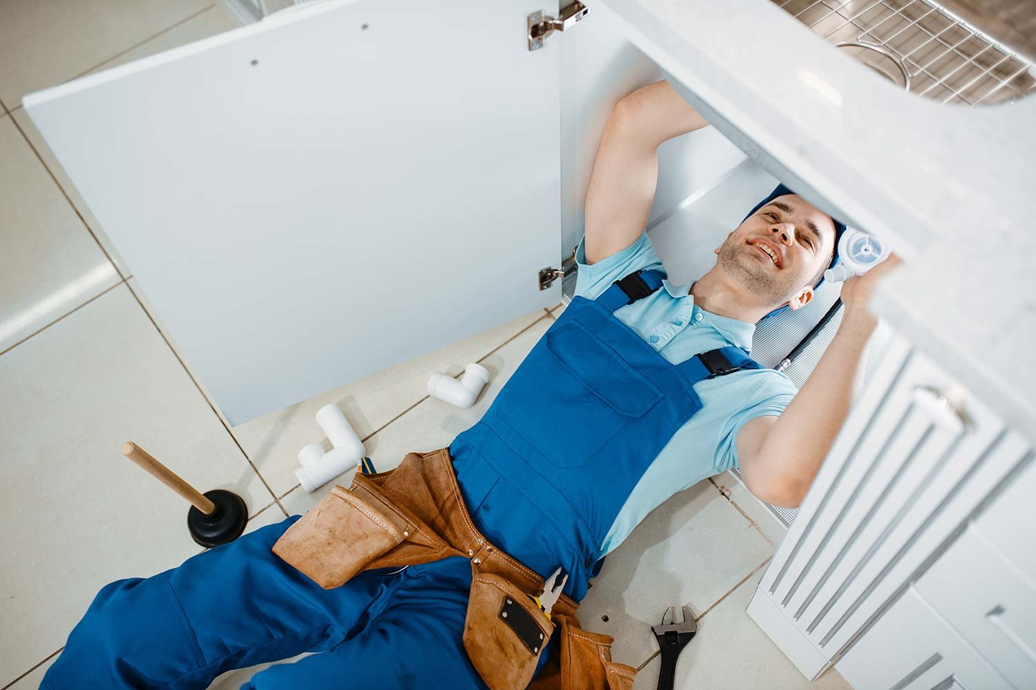 plumber-in-uniform-installing-drain-pipe-top-view-resize.jpg
